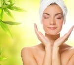 Beautiful young woman applying organic cosmetics to her skin